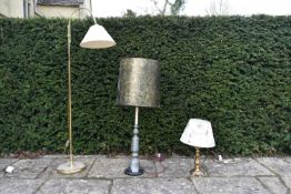 An adjustable brass standard reading lamp, a large pewter table lamp and a brass table lamp with