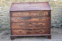 A Georgian figured mahogany bureau with fall front enclosing fitted interior above four long