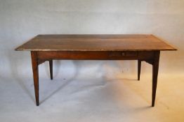 A 19th century pine planked top refectory style dining table with cleated ends and frieze drawer