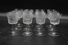 A set of twelve hand cut and machine engraved sherry glasses with foliate and cross hatched