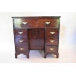 A 19th century mahogany kneehole desk with central drawer above panel cupboard flanked by pedestal