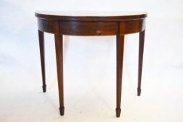 A Georgian mahogany and satinwood crossbanded demi lune tea table with fold over top on double
