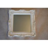 A bevelled wall mirror in painted Rococo frame. H.60 W.60cm