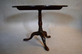 A Georgian mahogany tilt top table with baluster turned pedestal on tripod cabriole pad foot