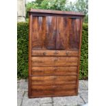 A late 19th century Continental flame mahogany cabinet with serpentine panel doors enclosing