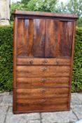 A late 19th century Continental flame mahogany cabinet with serpentine panel doors enclosing