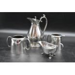 A collection of various silver plate tableware including a tall jug, twin handled pot, small milk