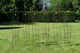 A set of six wrought metal lawn wind chimes with Fleur de Lys finials and scrolling decoration. H.