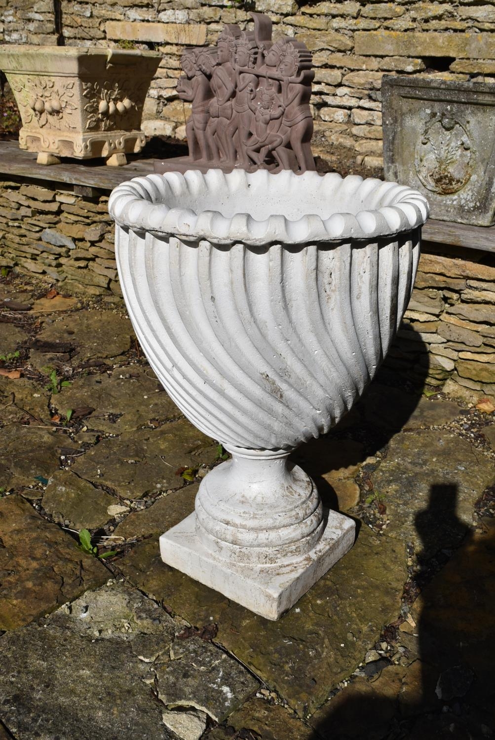 A painted reconstituted stone garden urn with spiral decoration on stepped base. H.68 Dia.46cm