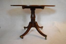 A 19th century mahogany tilt top table on swept quadruped supports terminating in brass casters. H.