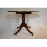 A 19th century mahogany tilt top table on swept quadruped supports terminating in brass casters. H.