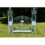 A pair of painted metal 19th century style garden gates with their posts and all over wrought