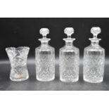 A set of three 20th century cut crystal glass topped decanters with a similar vase. H.27cm (