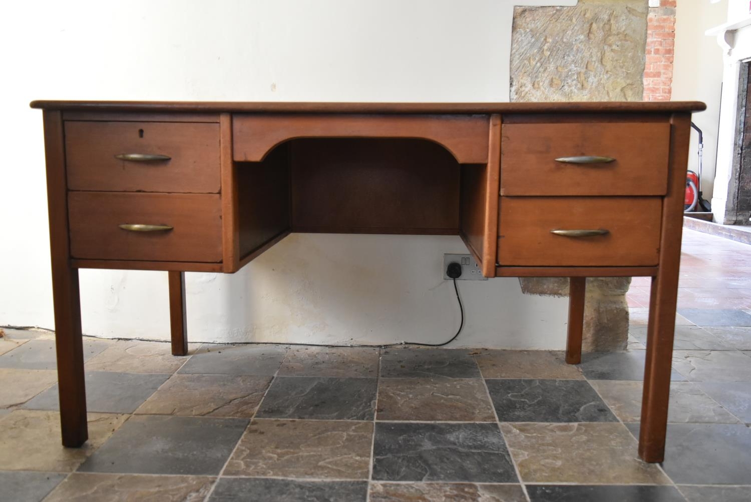 A vintage teak desk with inset gilt tooled leather top on square legs. H.74 W.135 D.75cm