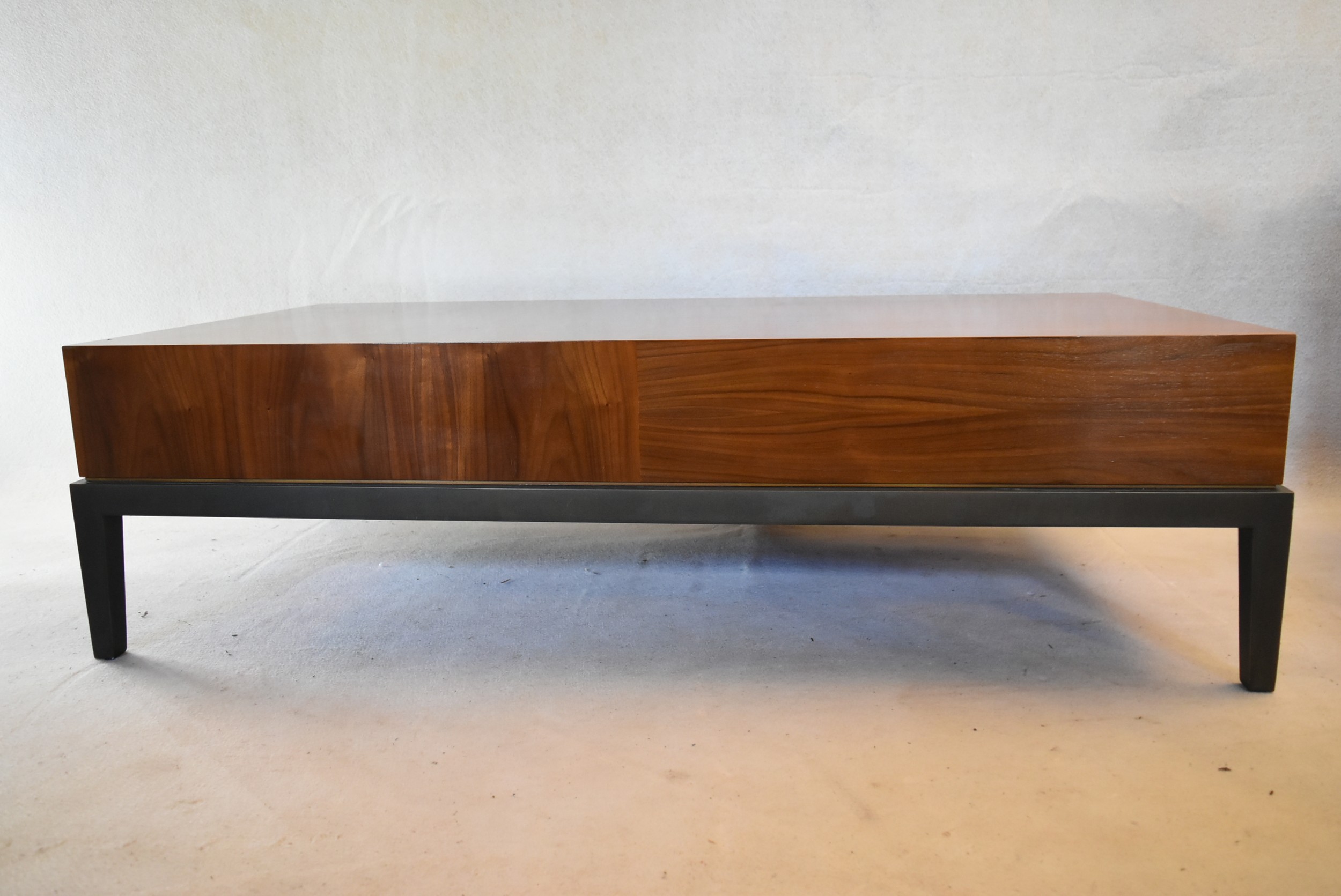 A contemporary teak coffee table fitted with end drawer on painted base with square tapering