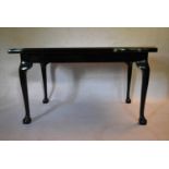 A mid century black lacquered centre table in the George III style with top inset with a variety