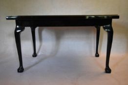 A mid century black lacquered centre table in the George III style with top inset with a variety