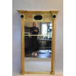 A large 19th century gilt framed pier mirror with architectural cornice above shell decorated frieze