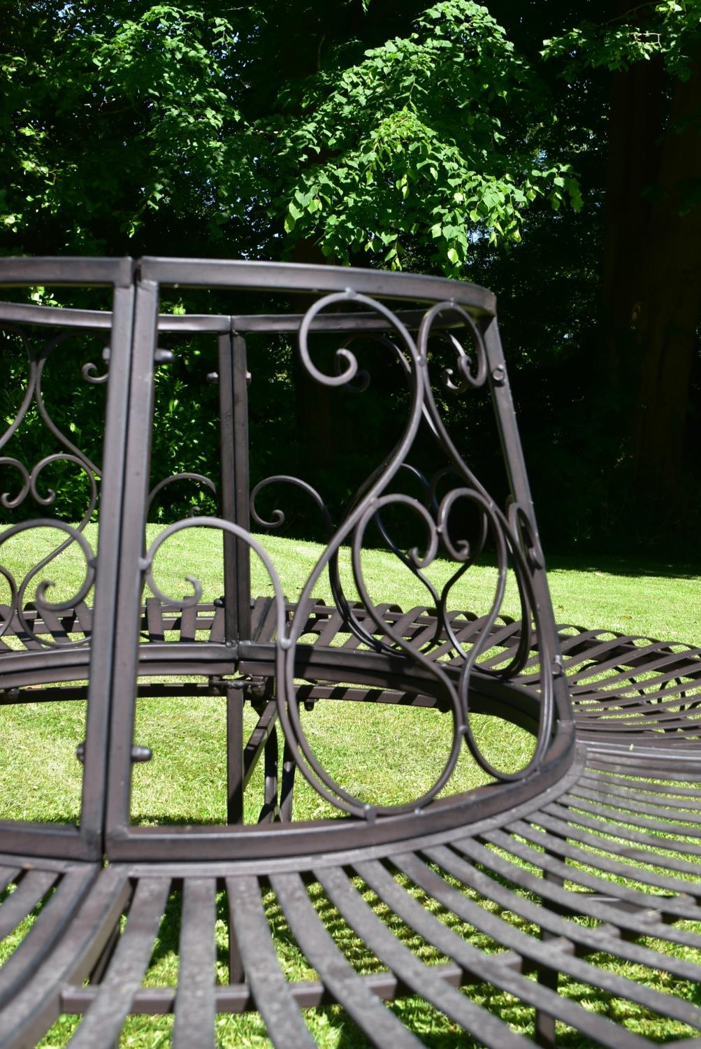 A wrought metal four section tree trunk bench with scroll decorated back and slatted seat. H.75 - Image 4 of 5