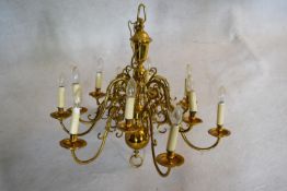 A large Dutch style brass chandelier with twelve scrolling branches in two tiers. H.81 W.85cm