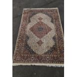 An Indian Agra carpet with triple floral pole medallions on a biscuit ground within spandrels and