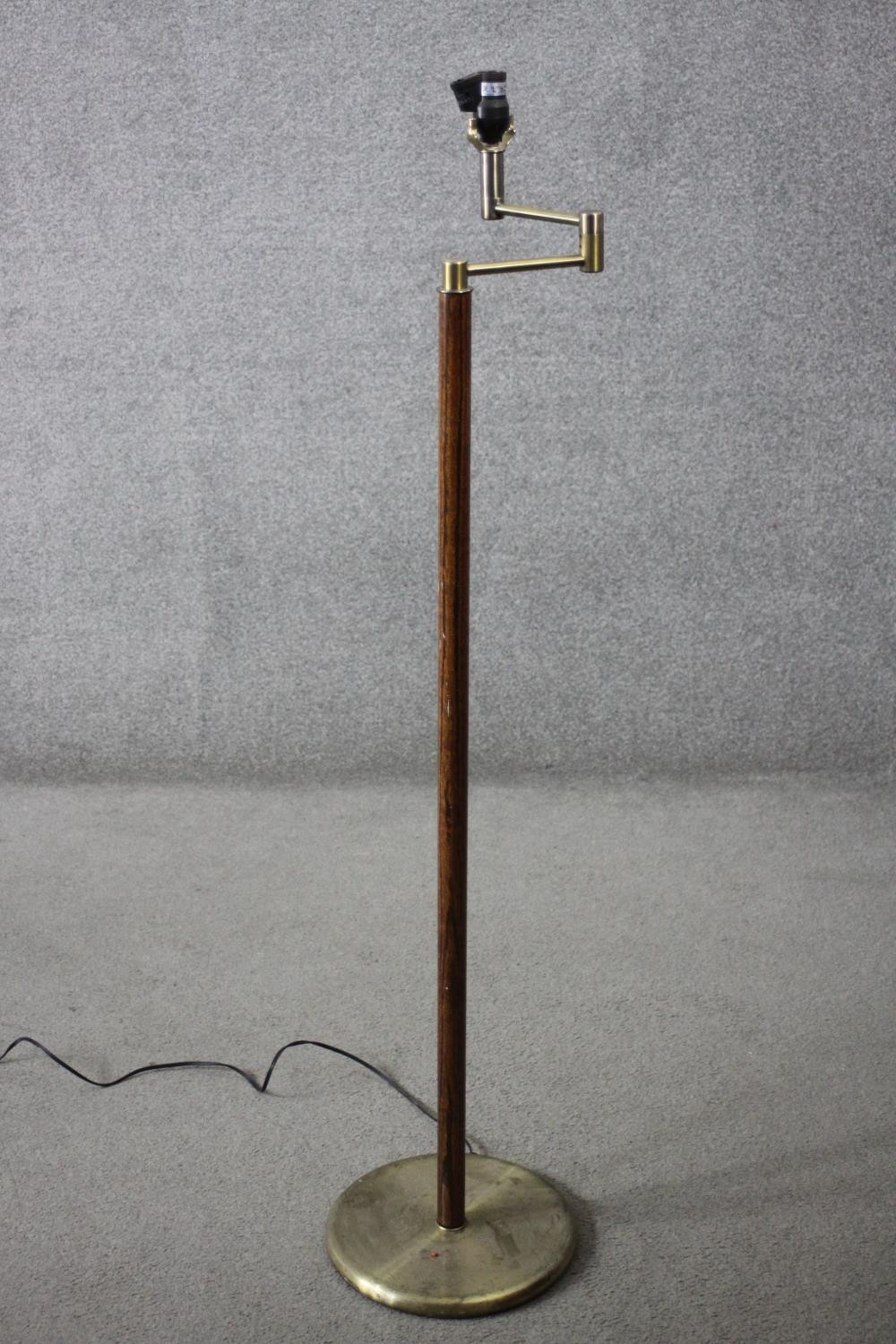 A vintage teak and brass standard lamp with hinged arm. H.143 Dia.30cm.