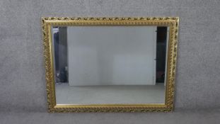 A large 20th century rectangular giltwood mirror with pierced foliate design frame. H.91 W.122cm