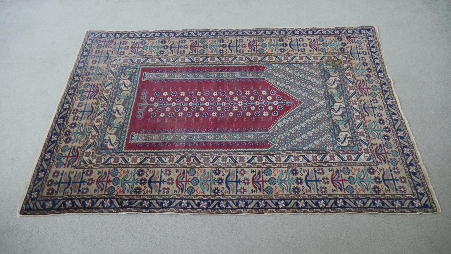 A Turkish Kayseri prayer mat with burgundy ground and floral multiple borders. L.170 W.115cm