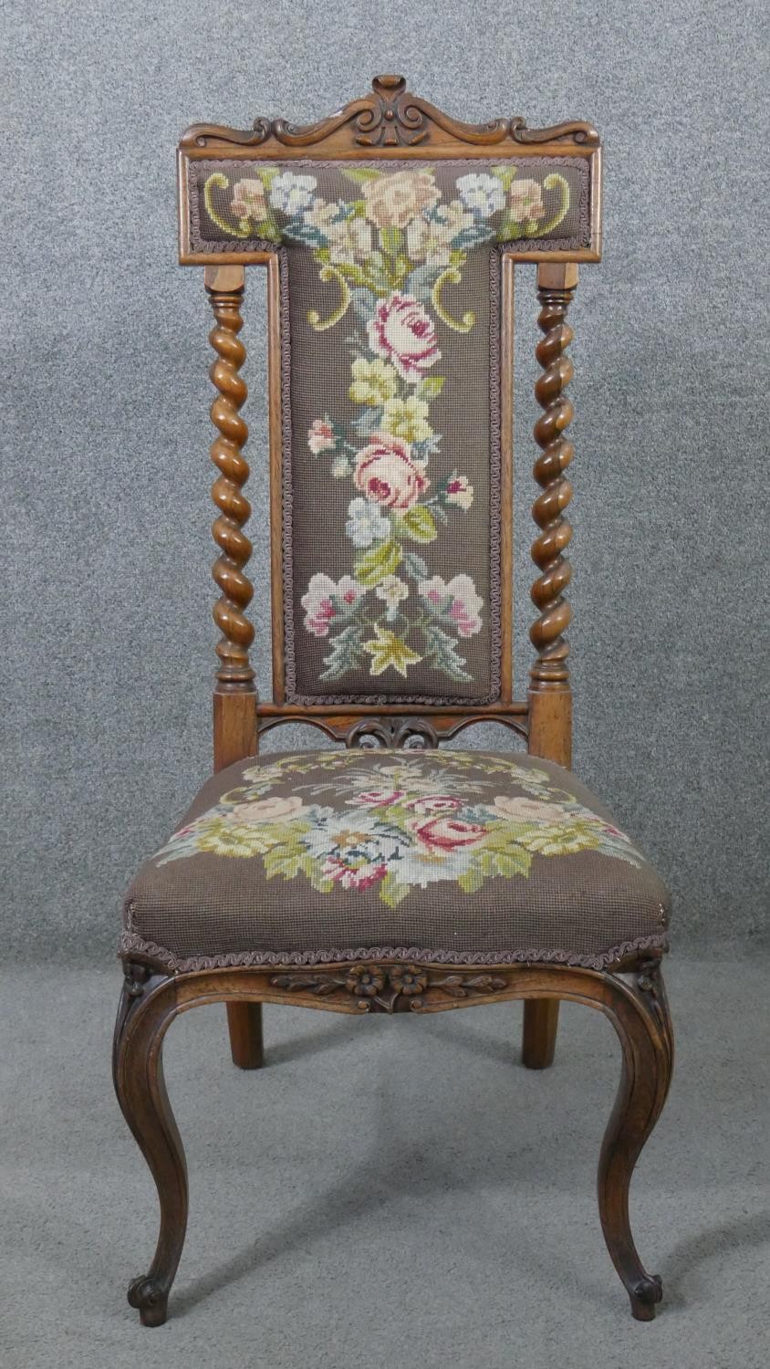 A Victorian carved rosewood prie dieu chair with barleytwist pilasters and floral tapestry
