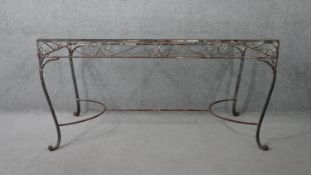 A vintage wrought iron garden or conservatory table with plate glass top. H.76 W.153 D.76cm