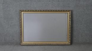 A contemporary gilded wall mirror with pomegranate and foliate design. H.62 W.86 cm