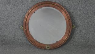 A C.1900 copper and brass hammered wall mirror with bevelled plate. H.37 W.42cm
