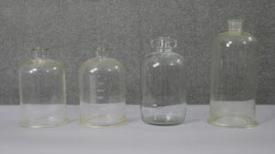 Four early 20th century glass apothecary jars and bell jars, some with numeric gradations. H.40