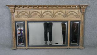 A Regency giltwood and gesso overmantel mirror with ball decorated architectural pediment above swag