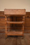 A late 19th century oak drop flap three tier buffet whatnot on turned supports terminating in
