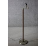 A vintage teak and brass standard lamp with hinged arm. H.134 Dia.30cm.