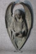 A large early 20th century wall mounted bronze angel statue. The angel holding a flower wreath. H.90