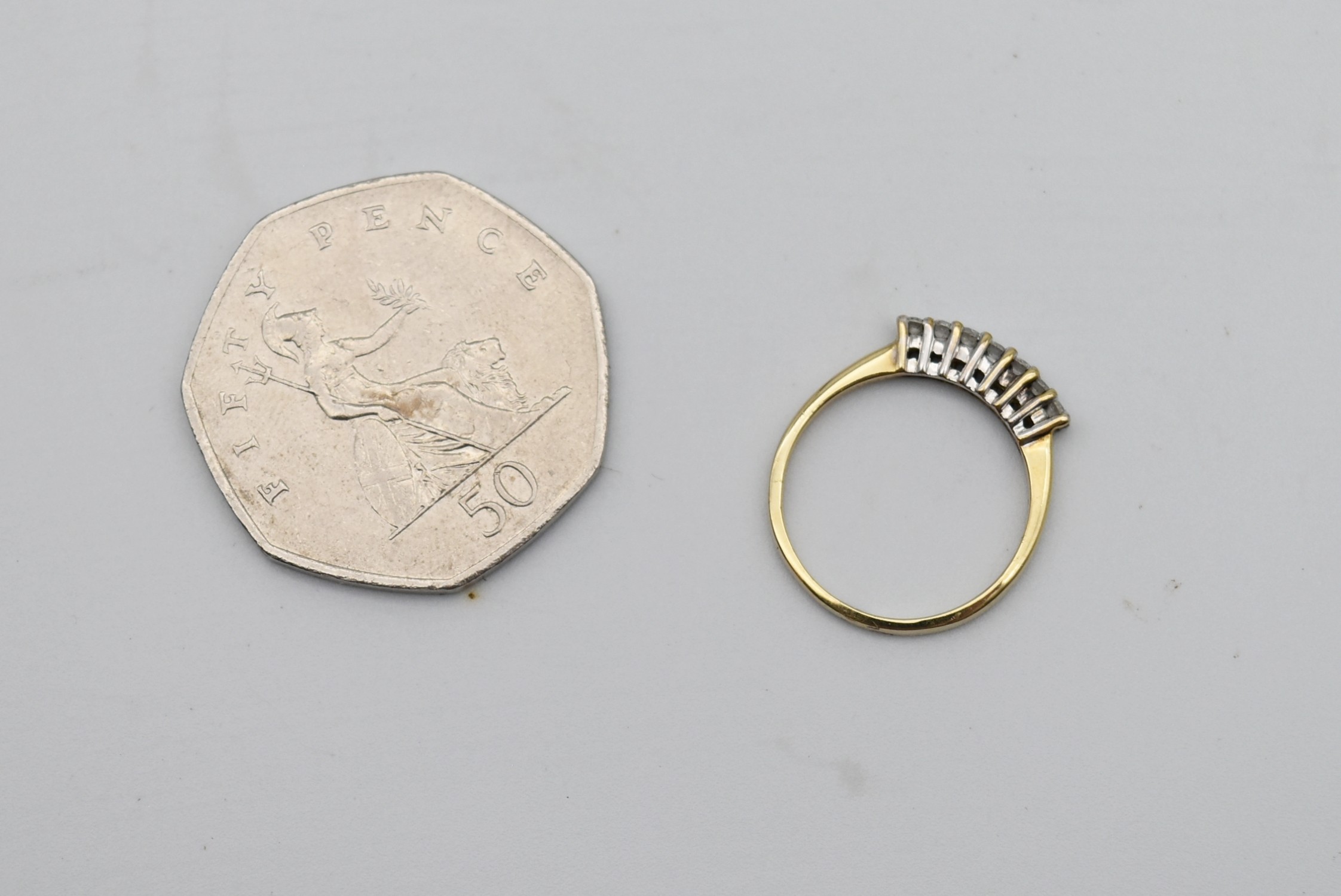 A seven stone diamond and 18 carat gold ring. Set with seven round brilliant cut diamonds in open - Image 6 of 7