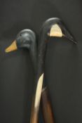 Two walking sticks with carved and painted duck head handles. L.90 cm.
