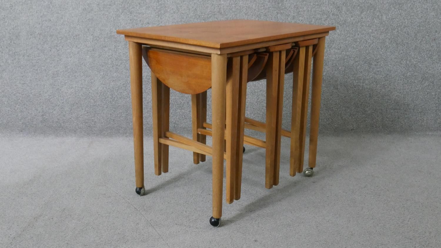 A vintage light teak nest of tables on beech supports fitted with three slide out drop flap - Image 3 of 8