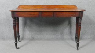 An early 19th century mahogany console or serving table raised on ring turned tapering supports