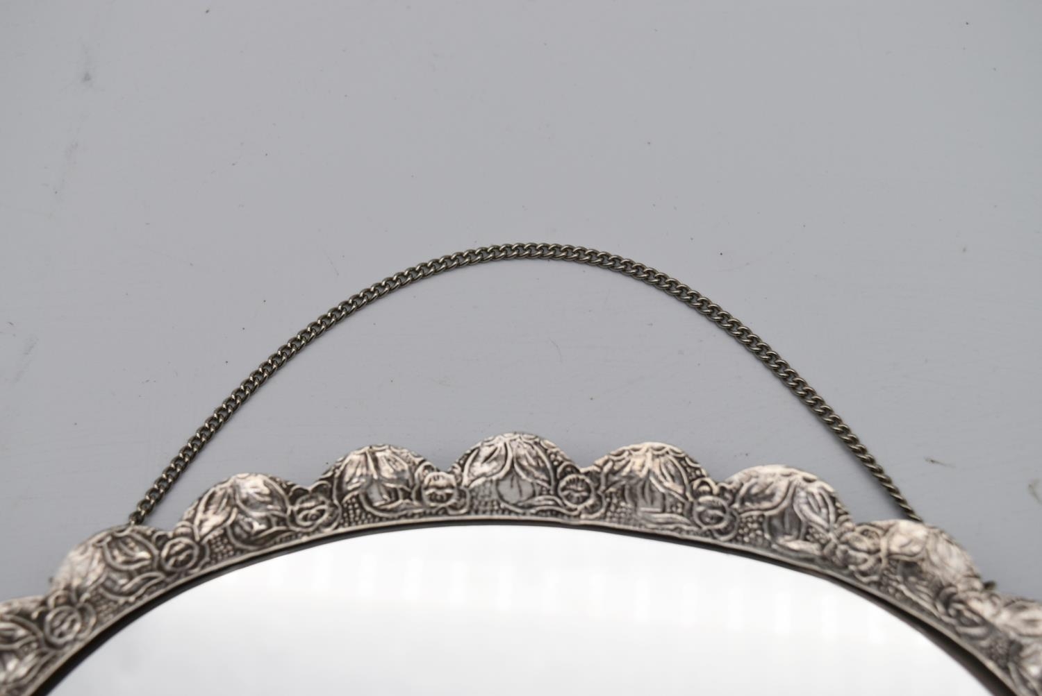 A 20th century Indian silver repousse mirror with stylised foliate and floral design and hanging - Image 3 of 8