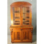 A late 19th century mahogany library bookcase with upper glazed section above drawers and panel