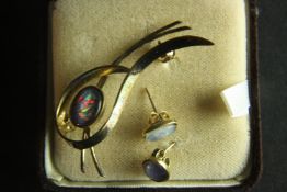 A boxed vintage Australian black opal doublet brooch and matching earrings. The stud earrings have