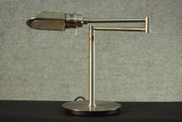 A contemporary brushed chrome table lamp with articulated hinged arm. H.34 Dia.20 cm.