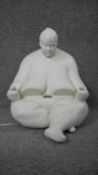 A white resin phone holder in the for of a seated sumo wrestler. With docking port for Ipad. Stamped