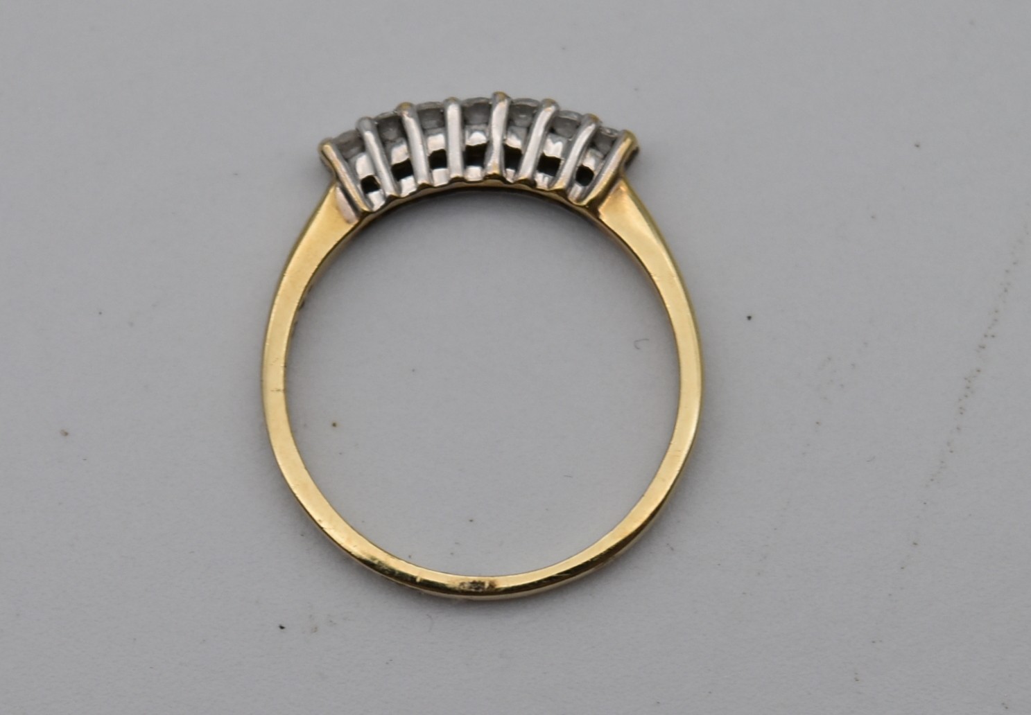 A seven stone diamond and 18 carat gold ring. Set with seven round brilliant cut diamonds in open