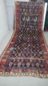 A large Kurdish runner with repeating motifs across the midnight ground within stylised multiple