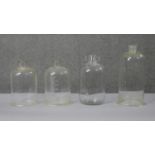 Four early 20th century glass apothecary jars and bell jars, some with numeric gradations. H.40