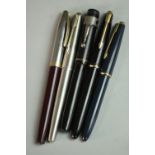 A collection of five 14 carat gold-nibbed vintage fountain pens, including a vintage Sheaffer PFM